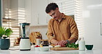 Kitchen, blender and man cutting fruit for breakfast with diet, wellness and health in home. Nutrition, ingredients and male person with mixer for beverage with weightloss snack in apartment.