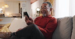Phone, smile and relax with old man on sofa for streaming, communication app and retirement. Subscription, contact and chat with senior person in living room at home for reading, search and online