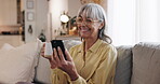 Phone, smile and coffee with old woman on sofa for streaming, communication app and retirement. Subscription, contact and chat with senior person in living room at home for reading, search and relax