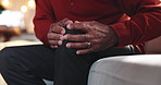 Senior, hands and sofa with knee injury or pain for arthritis, joint inflammation or fibromyalgia at home. Closeup, elderly patient or massage with sore leg, bone or nerve for osteoarthritis disease