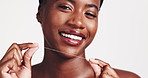 Black woman, teeth and dental floss with smile in studio for hygiene, oral or gum care on a white background. Portrait, female person or happy model with thread for cleaning mouth, breathe or cavity