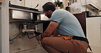 Fixing, maintenance and wrench with plumber in kitchen of home for repair of pipes or water flow. DIY, plumbing and upgrade with man in apartment for evaluation, renovation or service of system