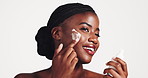 Black woman, face cream and skincare with beauty in studio for moisturizer on a white background. Happy, female person or model with smile or lotion in satisfaction for facial treatment or skin glow