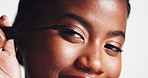 Black woman, face and eyelashes with mascara for beauty, cosmetics or volume on a white studio background. Portrait, female person or model applying eye makeup with tool for thickness or length