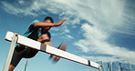 Man, running and jump for hurdle outdoor of fitness competition, run exercise and sports performance. Male athlete, field and obstacle race for cardio training, challenge and endurance goals