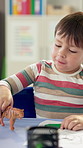 Boy, child and playing with toy in classroom for kindergarten education, learning or childhood development. Student, kid or elementary with tiger or drawing for fun creative imagination at school