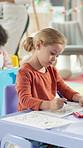 Girl, drawing or playing in classroom for learning, education or childhood development. Child, student or elementary kid coloring with paper or butterfly for creativity or fine motor skills at school
