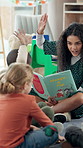 Happy woman, teacher and reading book with hands raised for question, answer or interaction at school. Female person, educator or kids with engagement for story time, learning or education in class