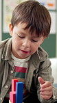 Kindergarten, child and boy with blocks for learning, creative and cognitive development in classroom. School, student and kid with building toys for education, motor growth and problem solving skill