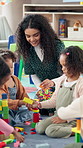 Building blocks, education and teacher with children in classroom for playtime in morning. Happy, students and educator helping kids with cognitive development, skills or growth at elementary school.