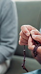 Hands, rosary and religion in home, couple and together for prayer, support and faith in living room. People, spiritual jewelry and crucifix for Christian worship, gratitude and Jesus at apartment