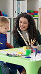 Teacher, happy children and painting for art in school with help, creativity class and color. Education, learning and woman talking to excited kids for development with paintbrush in kindergarten