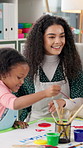 Teacher, child and painting for art at school with help, creativity and happiness with color. Education, learning and kid with woman for development with paint and brush for kindergarten artwork