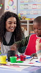 Art, education and painting with student and teacher in classroom for development, learning or study. Children, school and teaching with kid and woman at desk for creative course or lesson together
