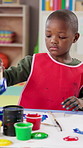 Painting, education and child in classroom at preschool for activity, hobby or cognitive development. Fun, student and African boy kid learn art for creativity, poster or sign at elementary academy.