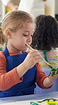 Student, child and painting on hand in classroom for handprint activity, art project and motor skills development. Kindergarten, girl kid and paintbrush for color artwork, creative lesson or learning