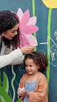 Teacher, student and child by wall with chalk for height, measurement or drawing by mural outdoor. Recess, creative and line for growth, woman and girl by flower painting at art academy or preschool