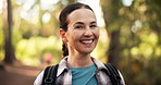 Face, smile and woman hiking in forest for trekking adventure, travel and fitness holiday. Portrait, female person and backpacking in woods for hobby, sightseeing and explore journey for getaway trip