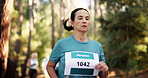 Woman, running or forest with marathon challenge for race, sprint or endurance test in nature. Mature, female person or runner with group for sport event, jogging competition or outdoor fitness