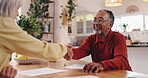 Handshake, senior man and meeting in home, smile and talking to woman for pension and retirement planning. Greeting, financial advisor and shaking hands with elderly person in house, advice and funds