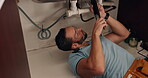 Plumbing, maintenance and man with wrench by sink for repairs, manual labor or trade for home improvement. Handyman, expert and person fixing pipes for leakage, drainage and service with tools