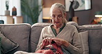 Hobby, relax and senior woman knitting in home for mental engagement, activity or creativity. Calm, retirement and elderly female person with needles and wool for handmade clothes in living room.