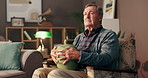 Home, death and senior man with grief, urn and thinking of loss in living room, mourning and sadness. Retirement, widower and elderly person with memories, contemplating and depression in house
