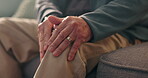 Hands, knee pain and old person with injury, arthritis or osteoporosis with muscle or joint ache in home. Torn ligament, discomfort and bone fracture, man on sofa with leg pressure or tension massage