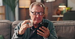 Senior man, phone and pills on sofa with search, online shopping or check label for product ingredients. Elderly person, smartphone and medicine with mobile app for order, stock or benefits in home