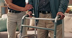 Caregiver, old man and hands with walker for support, assisted living facility or nursing home for wellness. Senior care, health and elderly person with healthcare worker for mobility or help walking