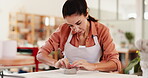 Clay, design and pottery with woman in boutique for crafting, manufacturing or production of ceramics. Concentration, creative and workshop with artisan or potter in studio gallery for sculpting