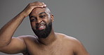 Hair, beauty and face of black man in studio for skincare, shampoo and grooming. Hairstyle, self care and cosmetics with portrait of person on grey background for barber, scalp and dermatology