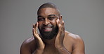Face, skincare and man with moisturizer in studio for treatment, self care and dermatology. Portrait, cream and happy African person apply cosmetics for hydration, glow or beauty on gray background