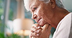 Thinking, regret and elderly woman with stress in living room of retirement home with dementia. Anxiety, worried and lonely senior female person with alzheimer, sad memory nostalgia and depression