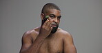 Face roller, skincare and beauty with black man in studio for lymphatic drainage, cosmetics and glow. Grooming, facial tools and dermatology with person on gray background for shine and self care