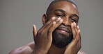 Studio, black man and face with hands for skincare, hygiene and model with confidence for wellness. Mockup space, male person and smile in portrait for dermatology, cosmetics and gray background