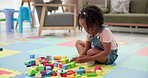 Building blocks, playing and child on floor in house for cognitive development or creativity. Learning, living room and girl kid with educational toys for fine motor skills or sensory in home.
