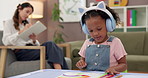 Child, girl and therapist with writing, notes and coloring book for assessment, checklist and headphones. Woman, kid and psychologist with clipboard, art and drawing with listening to music at clinic