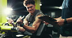 Strength, trainer and man with machine, gym and exercise for wellness, clipboard and writing progress. Health club, instructor and person with fitness for body, routine and bodybuilder with power