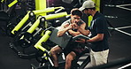 Tablet, fitness and men in gym, fist bump and support with challenge, training and personal trainer. People, instructor and bodybuilder with tech, hand gesture and app for progress or exercise goals