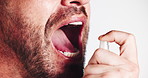 Man, spray and mouth with fresh breath for mint, oral care or hygiene on a white studio background. Closeup, male person or model with perfume, smile or clean teeth for odor smell or dental fragrance
