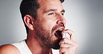 Happy man, spray and mouth with fresh breath for mint, oral care or hygiene on a white studio background. Male person, model or smile with perfume, clean teeth or odor for smell or dental fragrance