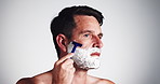 Cream, razor and man in studio with shaving for self care, grooming or epilation treatment. Cosmetic, health and person with shaver for facial hair removal routine for smooth skin by white background