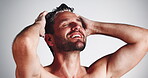 Hygiene, man or hair washing with shampoo for scalp cleansing, dandruff removal or grooming routine. Happy, person or self care with haircare product for healthy growth and shine on studio background