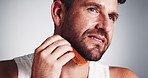 Studio, grooming and man with beard, comb and smile for fresh shave, routine and facial treatment. White background, self care and person with happiness for haircare, morning and guy with equipment