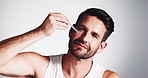Face, serum and man with skincare, cosmetics and dermatology on white studio background. Portrait, happy person and model with treatment, beauty and oil product in pipette with hydration and glowing