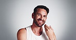 Studio, grooming and man with beard, touch and smile for fresh shave, routine and facial treatment. White background, self care and person with happiness for haircare, mockup and  guy in morning