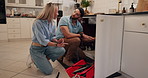 Man, assistance and kitchen with plumber for repair, water leak or fixing customer sink at home. Male person, handyman or artisan or helping woman with pipe damage for quote or maintenance service