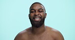 Smile, skincare and face with black man in studio for beauty cosmetics, dermatology and self care. Clean, glow and male grooming with person on blue background for hydration, collagen and shine