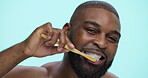 Face, oral care or black man brushing teeth in studio on blue background for dental check, wellness or smile. Portrait, happy or African model in routine for satisfaction, cleaning mouth or beauty